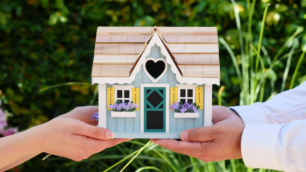 Photo d'un homme et une une femme qui tiennent une miniature d'une maison